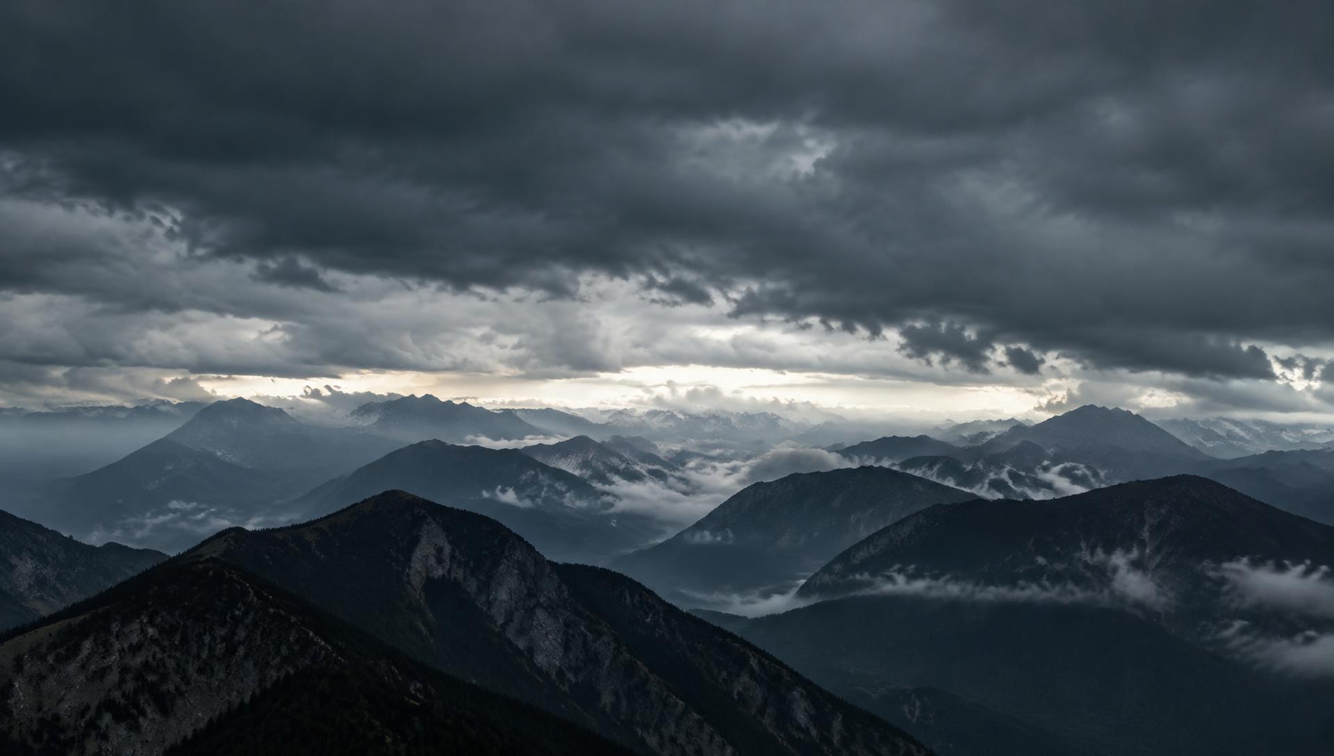 Layered mountain ridgelines beneath a storm-grey sky